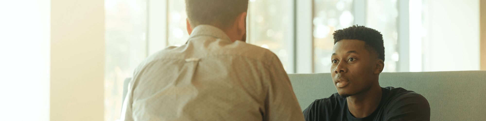 Two males sitting opposite each other as they participate in a job interview